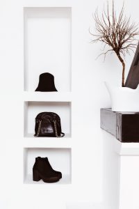 Women's fashion accessories in white interior. Hats, bags, shoes. Black style in clothes