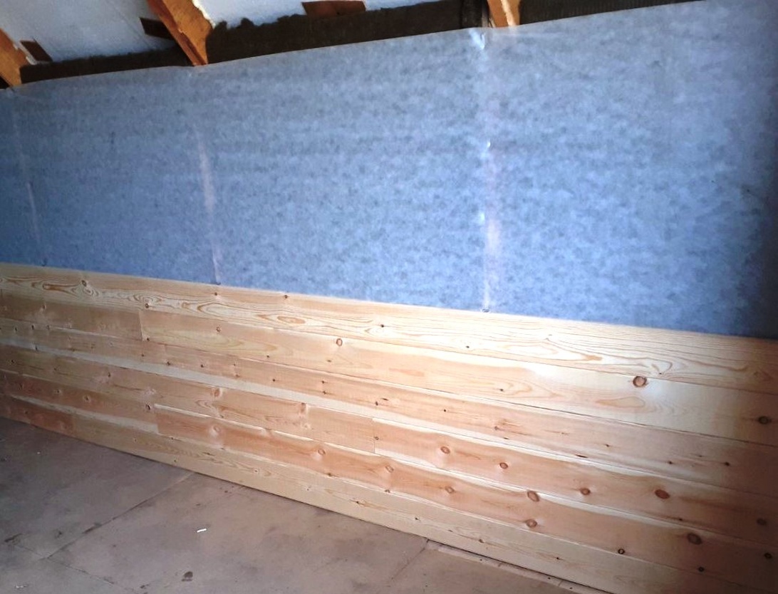 En moderne stue med stilfulle spilepaneler i eik på veggen bak sofaen, noe som skaper en varm og innbydende atmosfære.